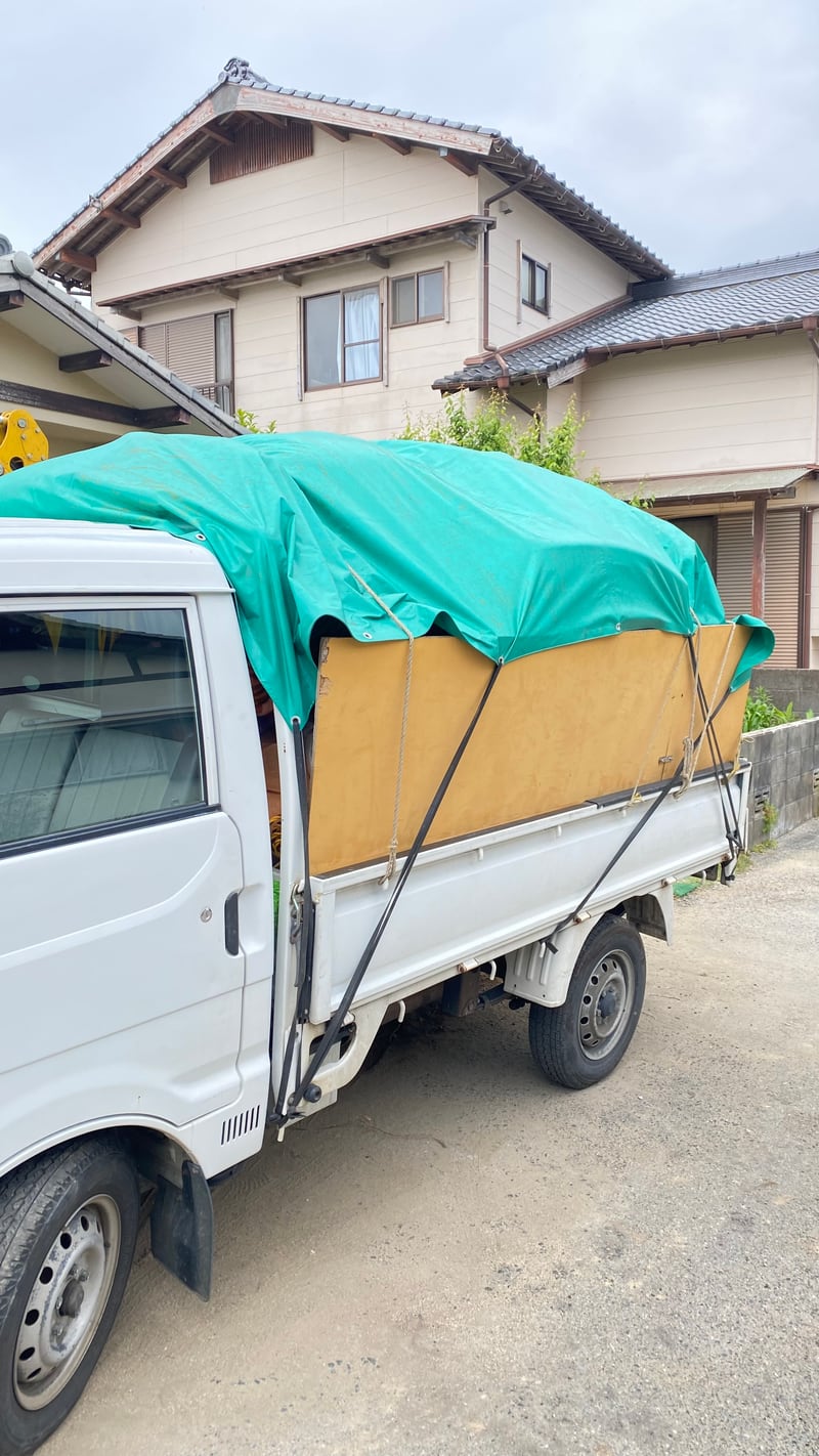 緑シートのトラック積み込み写真